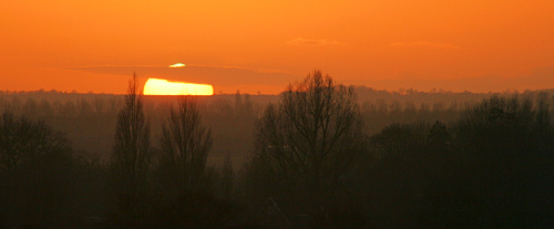 Landscape fading into distance as sun sets