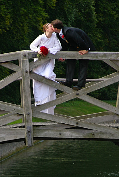 Wedding bride and groom kissing on bridge